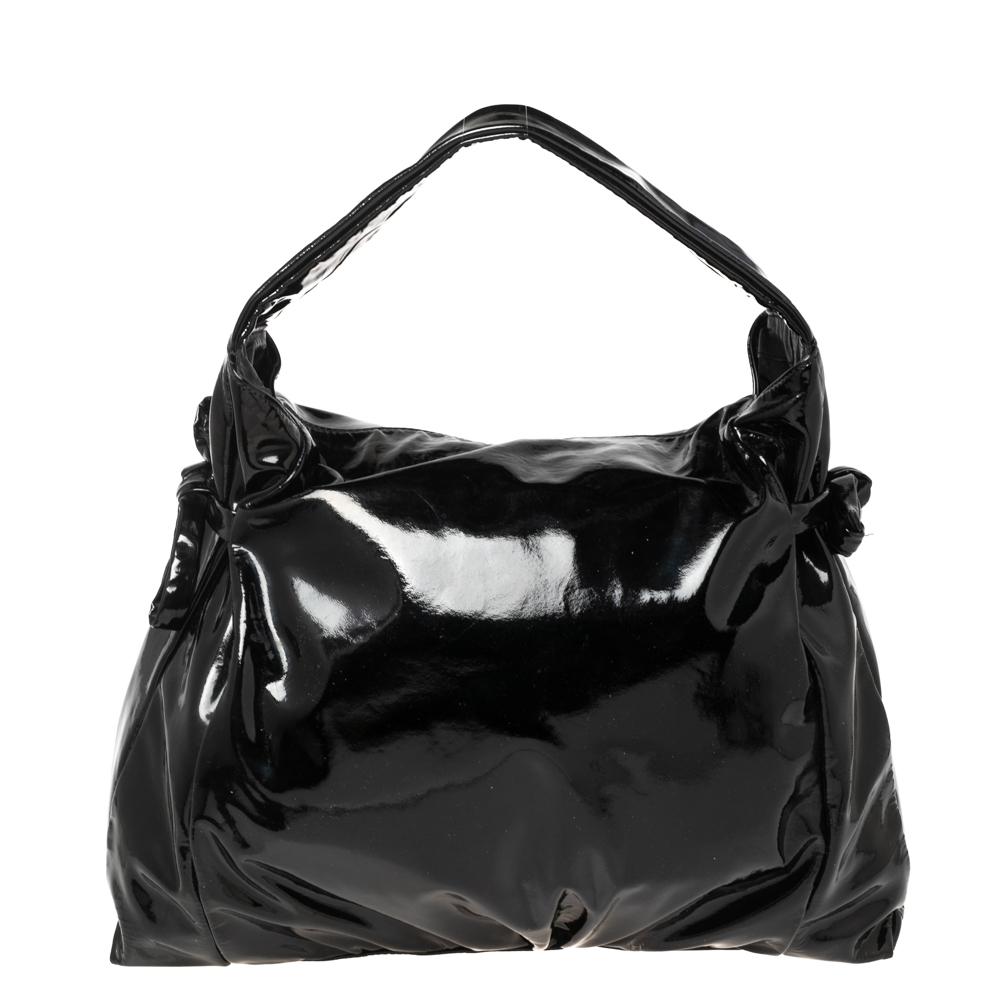 This Gucci hobo strikes the right balance of style, elegance, and functionality. Crafted from black patent leather, it features gold-tone hardware and a single, sturdy handle. The roomy interior ensures easy housing of all your essentials. Team with