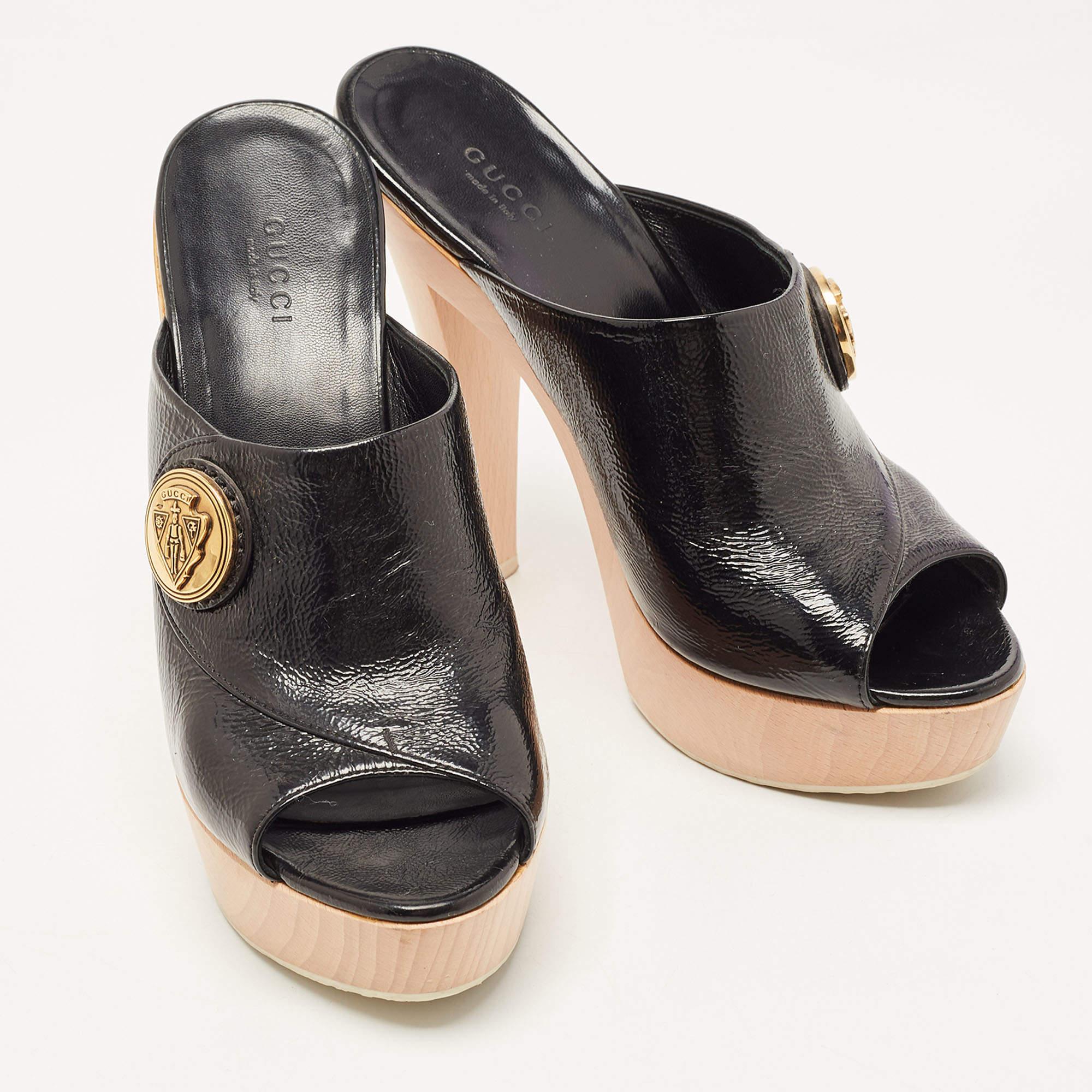 These Gucci Hysteria platform clogs are comfortable and stylish. They have been crafted in Italy and are made from patent leather in black. They have an open toe silhouette, platforms, and 14.5cm heels. They come with leather lining and feature the