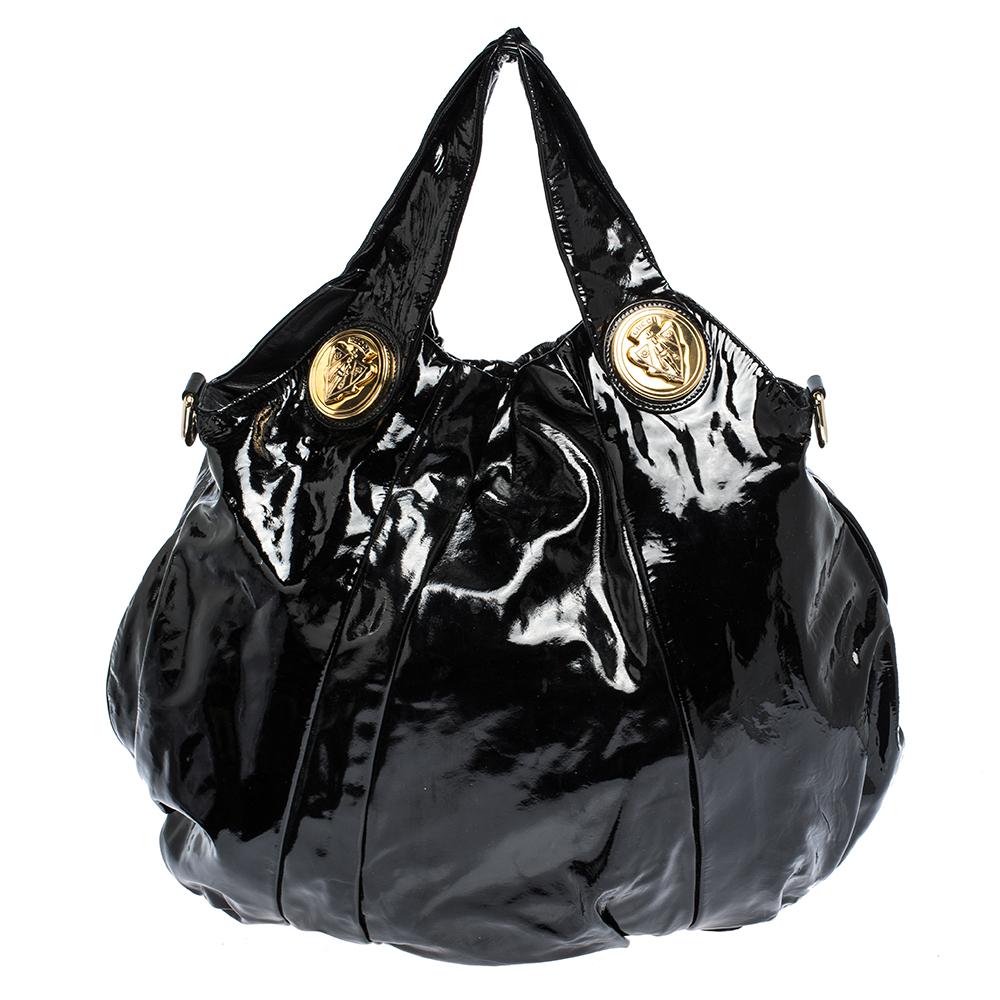 Undisputedly stylish and brilliantly designed, you cannot go wrong with this bag. Be the talk of the town when you carry this in-vogue Gucci bag. This Hysteria bag is crafted from black-hued patent leather and is styled with dual top handles. It
