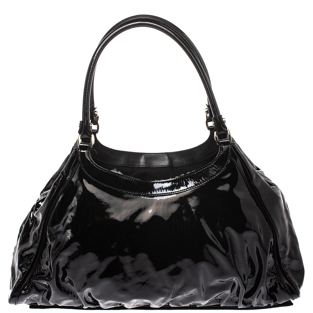 Gucci brings to you this amazing D Ring hobo that is smart and modern. Made in Italy, this black hobo is crafted from glossy leather and features a single top handle and a D shaped ring at the front. The zip fastening at the top reveals a