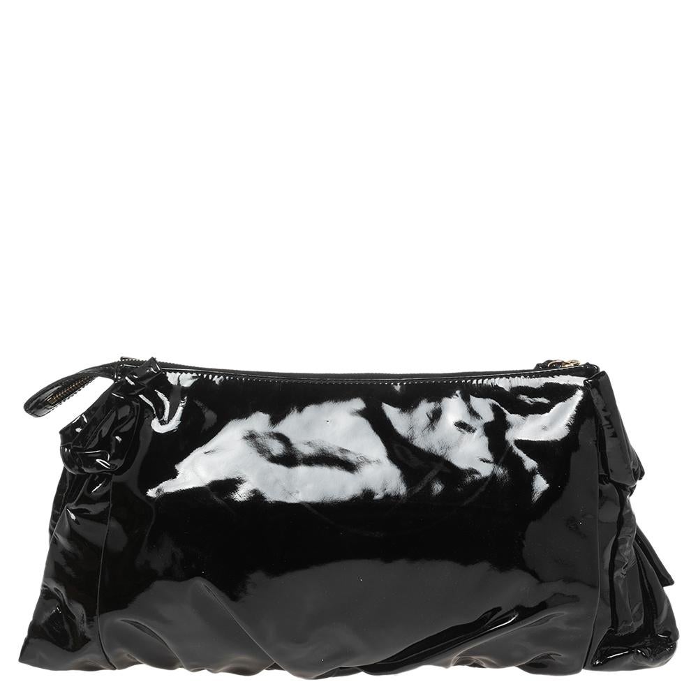 The Hysteria clutch is an iconic creation from the House of Gucci. It is made from black patent leather, with a gold-tone Hysteria motif perched on the front. It opens to a nylon-lined interior that can easily carry all your daily essentials. Swing