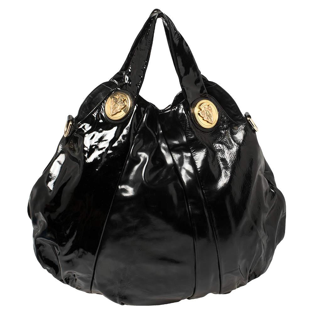 This Gucci hobo is built for everyday use. Crafted from patent leather, it has a black exterior and two handles for you to easily parade it. The nylon and leather insides are sized well and the hobo is complete with the signature emblems.

Includes: