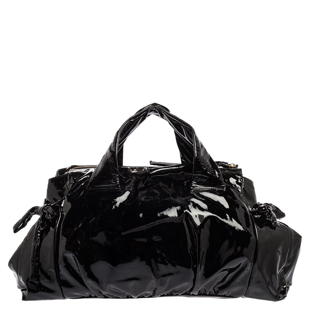 This Gucci tote is built for everyday use. Crafted from patent leather, it has a black exterior and two handles for you to easily parade it. The nylon insides are sized well and the tote is complete with the gold-tone signature emblem.

Includes: