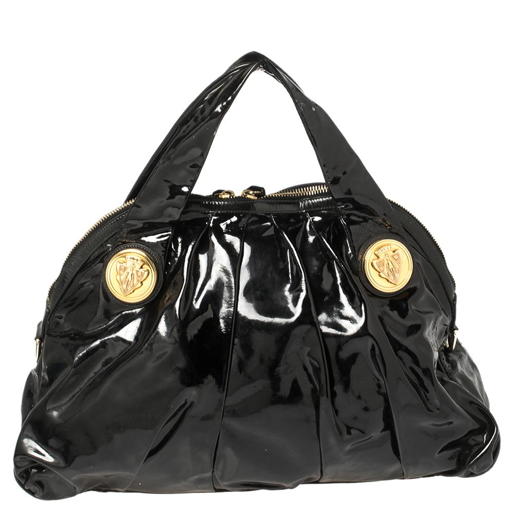 This Gucci Hysteria tote is built for everyday use. Crafted from patent leather, it has a black exterior and two handles for you to easily parade it. The nylon insides are sized well and the tote is complete with the gold-tone signature emblem on