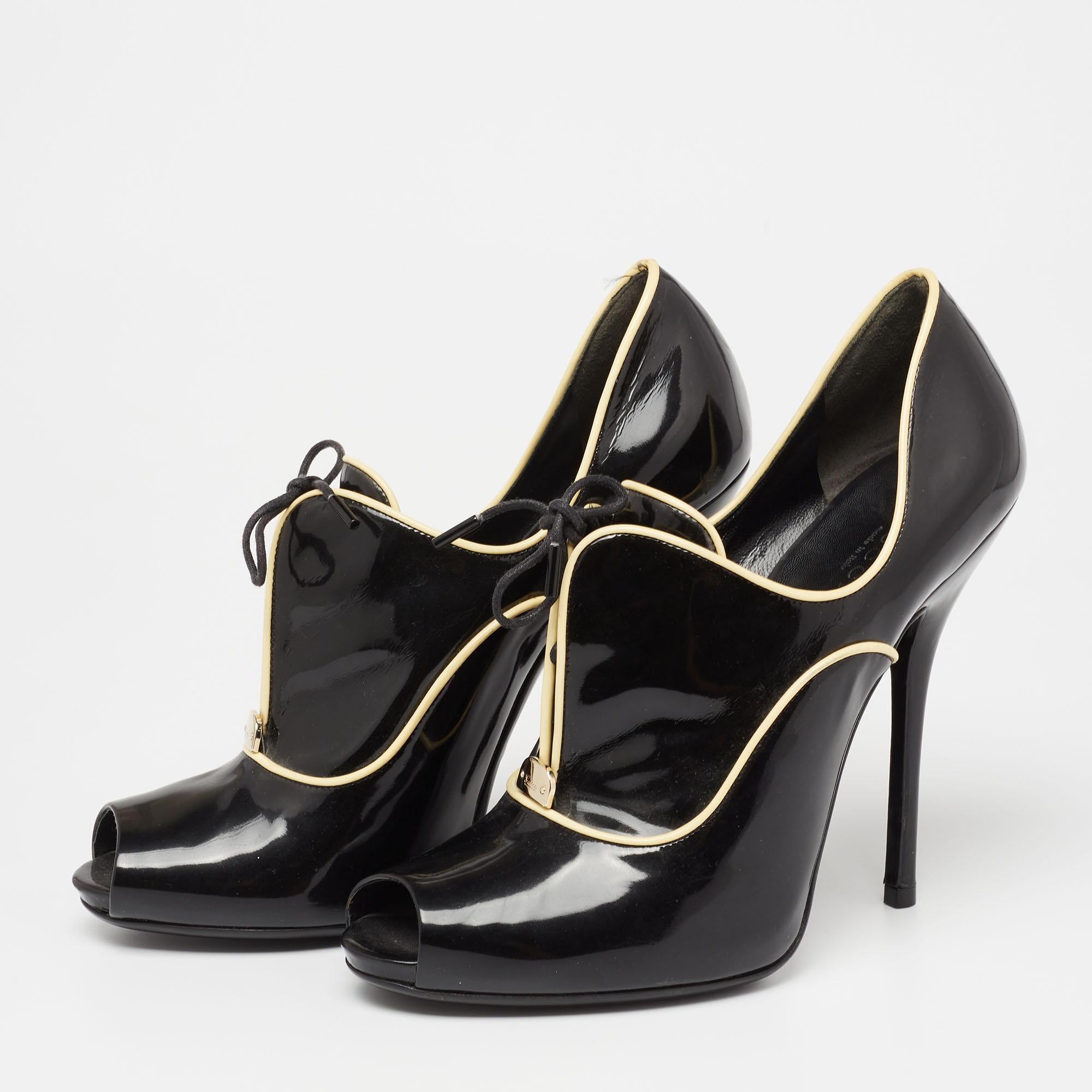 Made in Italy, this pair of Gucci ankle booties is beautifully designed with black patent leather and contrasting trims. The shoes have peep toes, lace-up details, and 13 cm heels giving the design a grand finish.