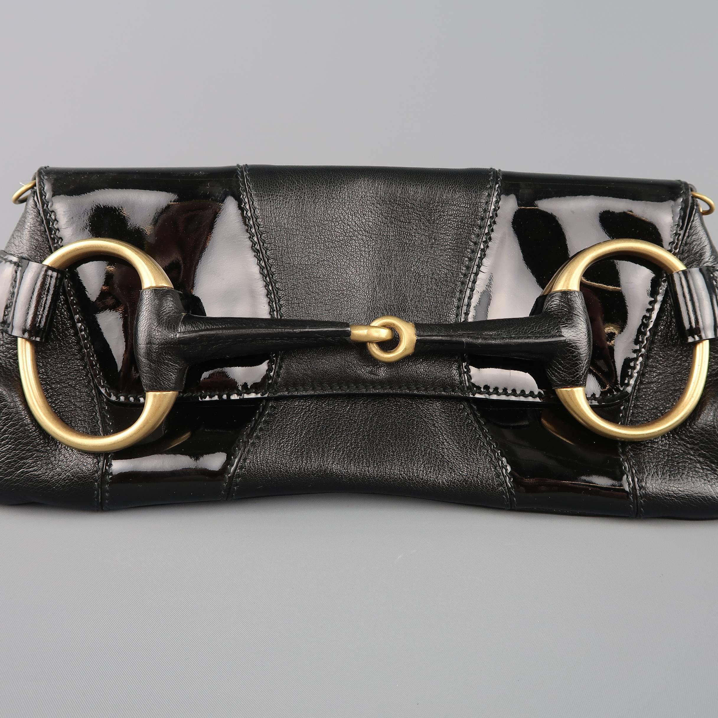 GUCCI clutch bag comes in textured black leather with patent leather panels and features a flap closure, oversized gold tone horsebit, and detachable chain shoulder strap. Made in Italy.
 
Good Pre-Owned Condition.
 
Measurements:
 
Length: 15