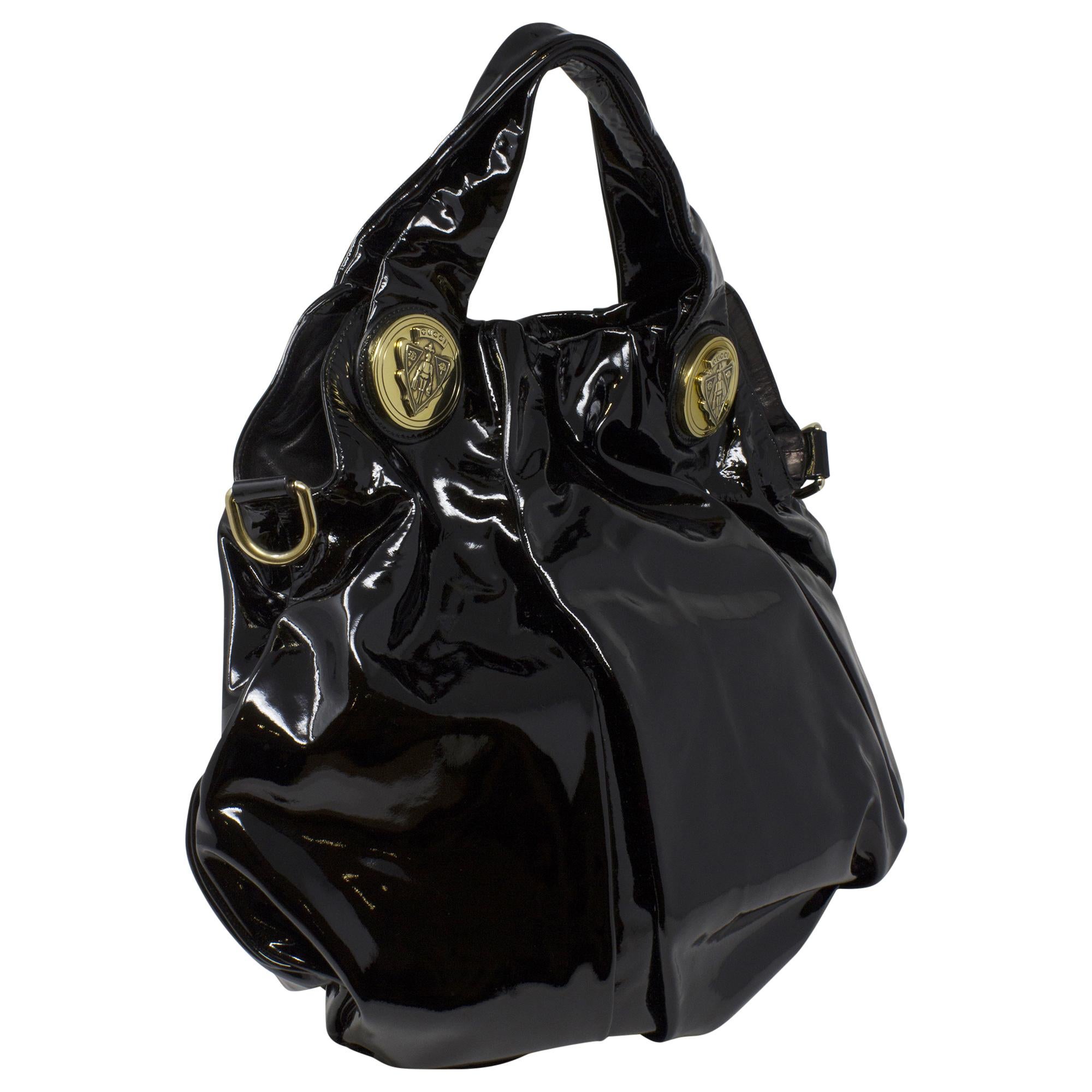Die Gucci Black Patent Tote ist ein elegantes und anspruchsvolles Accessoire für die moderne Fashionista. Diese Tasche aus luxuriösem schwarzem Lackleder strahlt Eleganz und Stil aus. Mit ihrem minimalistischen Design und den silbernen