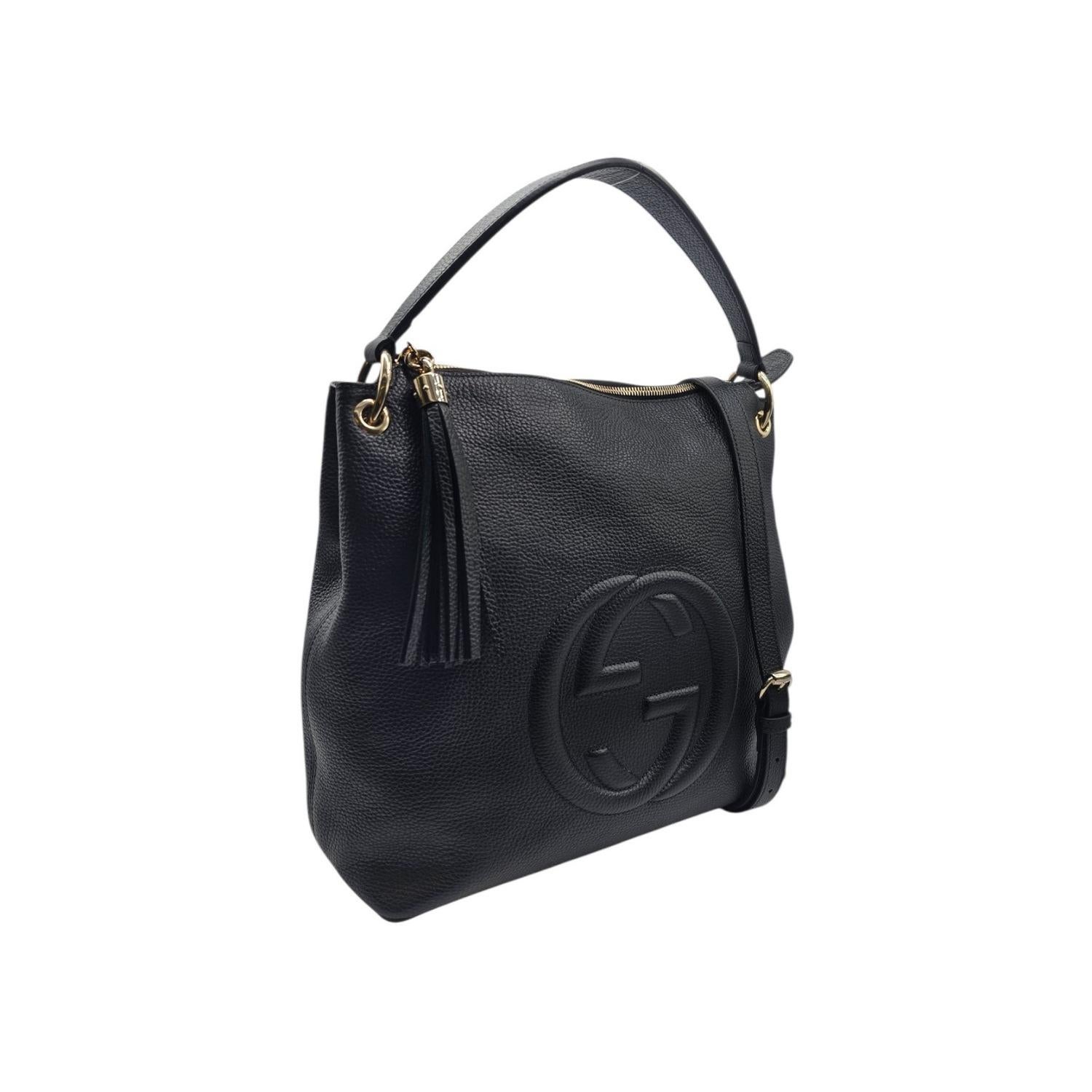 This Gucci Pebbled Calfskin Large Soho Hobo Bag is crafted of soft pebbled calfskin leather in black. The bag features a leather top handle, an optional leather shoulder strap with brass links, a tassel zipper pull, and a stitched interlocking G