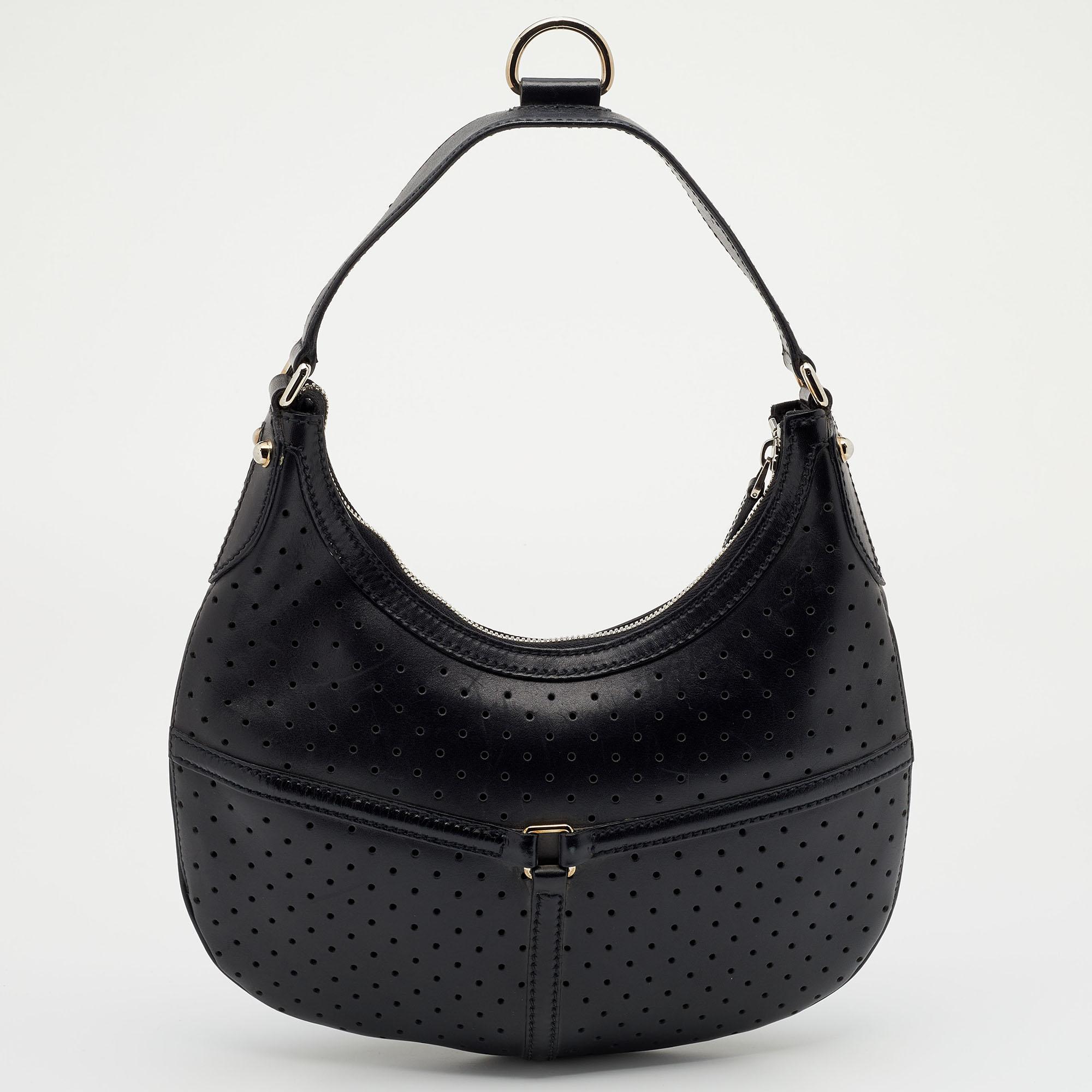 This Gucci hobo will conveniently hold all your essentials in great style. Fashioned in perforated leather, this classic bag comes with a top zip closure and the GG logo on the front. This hobo is ideally sized to carry your essentials like cell