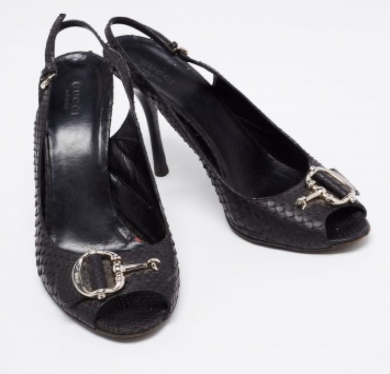 Diese schönen schwarzen Sandalen aus Pythonleder sind ein hervorragendes Beispiel für Luxus und Eleganz. Ein Paar umwerfende Gucci-Sandalen wie diese sind ein absolutes Muss im Kleiderschrank. Sie sind mit Peep-Toes, Slingbacks, Icon Bit-Details auf