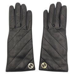 Guanti Gucci in pelle nera trapuntata con logo dorato