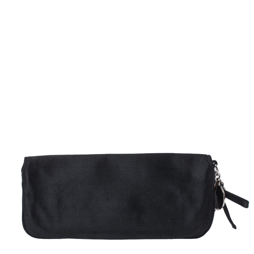 Exclusively designed by the iconic house of Gucci, this stylish clutch is perfect for night-time parties and special evenings. Crafted from luxurious satin in Italy, it comes in a lovely shade of black. It has a front flap with sparkling crystal