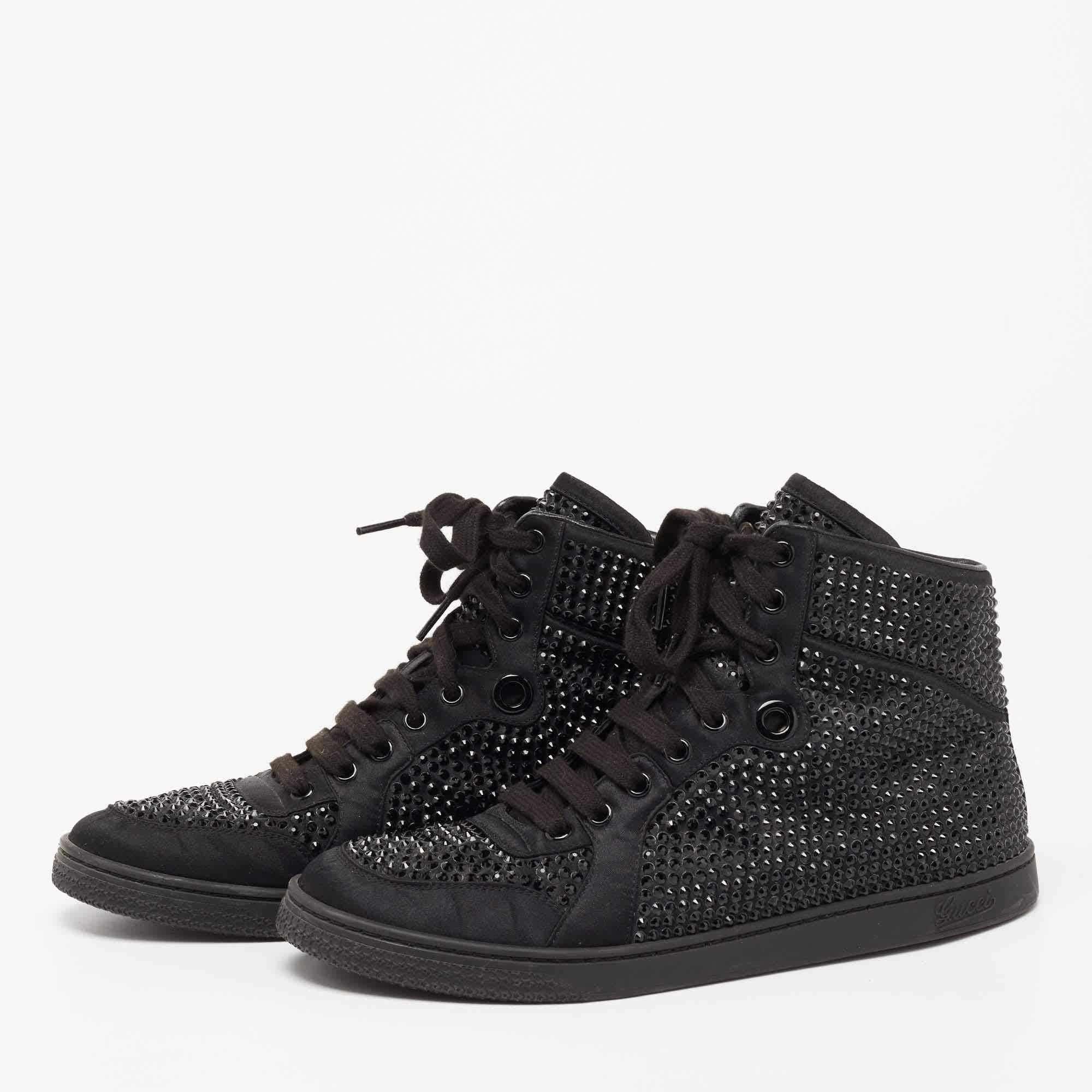 Amp up your casual style as you wear these high top sneakers from the House of Gucci. Black satin material is used to create its sturdy exterior. To add to its beauty crystal embellishments and matching black toned hardware are used to decorate the