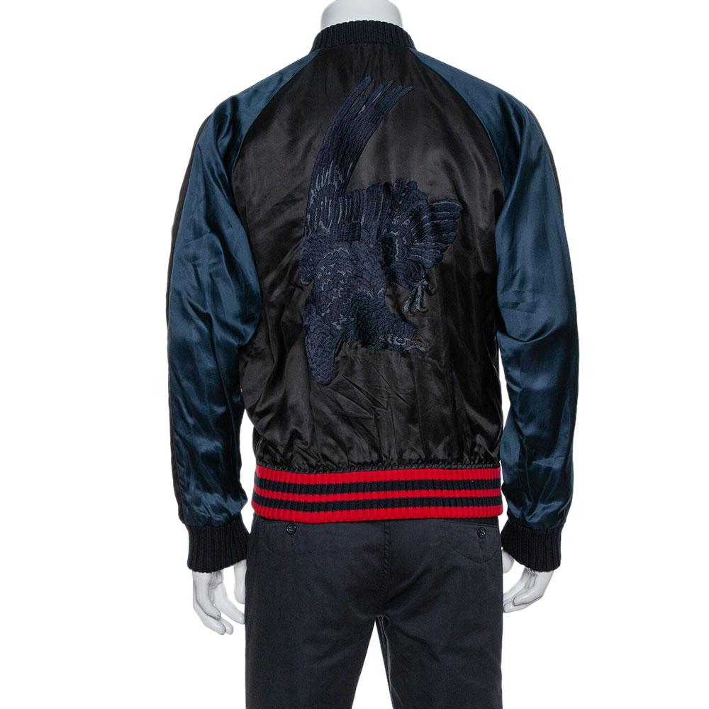 In more ways than one, this black bomber jacket from Gucci is an incredible piece of luxury. It has a comfortable shape, great tailoring signs, and a luxurious design. Cut from satin, the jacket features a front zipper, embroidered details, and two