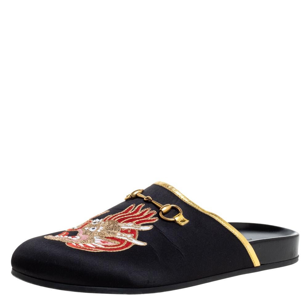 Beautifully designed, these mules from Gucci are truly charming! They are crafted from black satin and styled with an open back silhouette. They exhibit dragon embroidered and Horsebit detailed vamps and come endowed with comfortable leather-lined