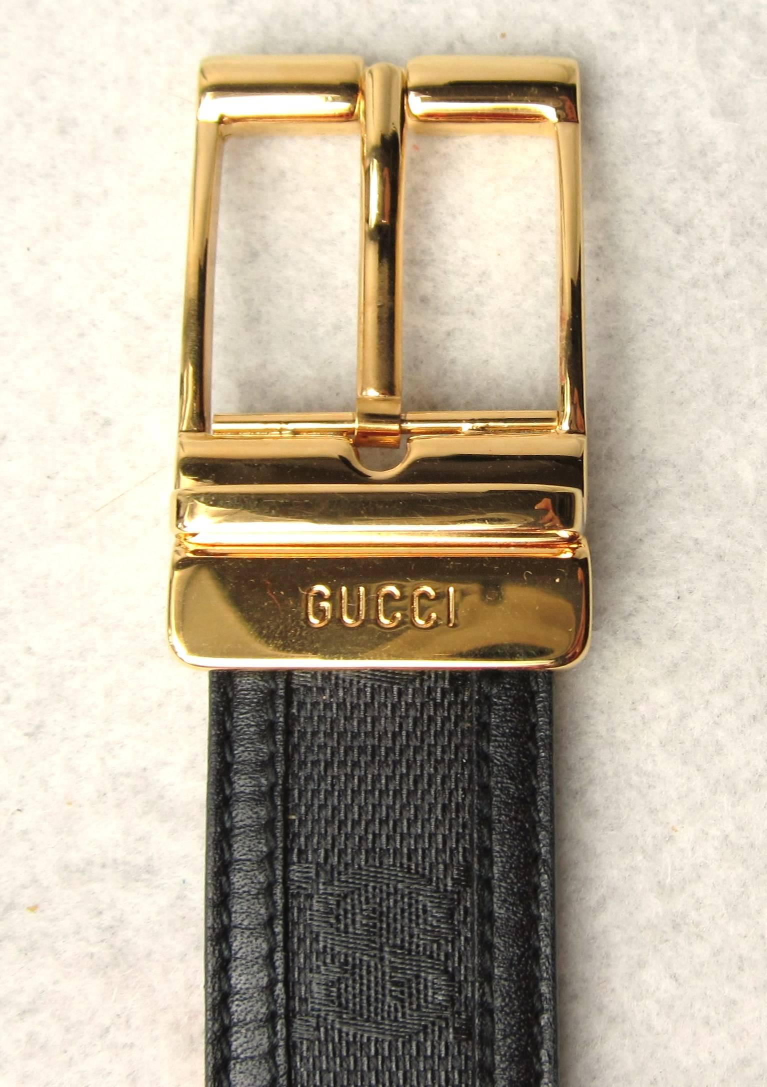 Gucci Black with Gold Tone Belt Buckle. Signature GG on the canvas with leather trim. This was purchased in the early 90s and still has the tag on it. Labeled a size 44 - Measures 1.15 inches wide. First belt hole is at 41 inches and the belt is 47