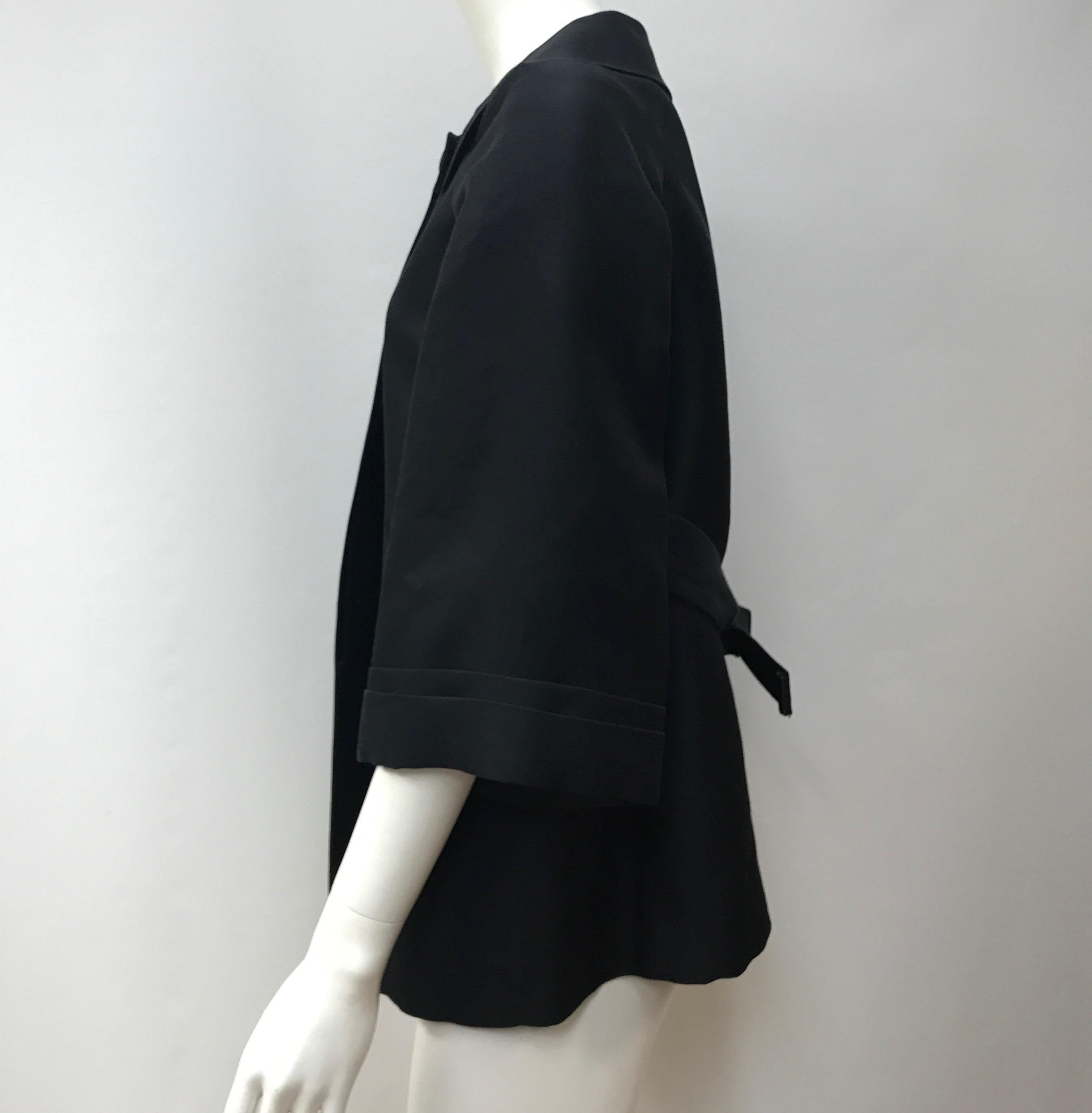 Gucci Black Silk Cape Jacket-42. This amazing Gucci cape jacket is in good condition. It only shows use to the underarms with slight staining, as shown in picture. It is made of black silk throughout. The sleeves are quarter length and there is a