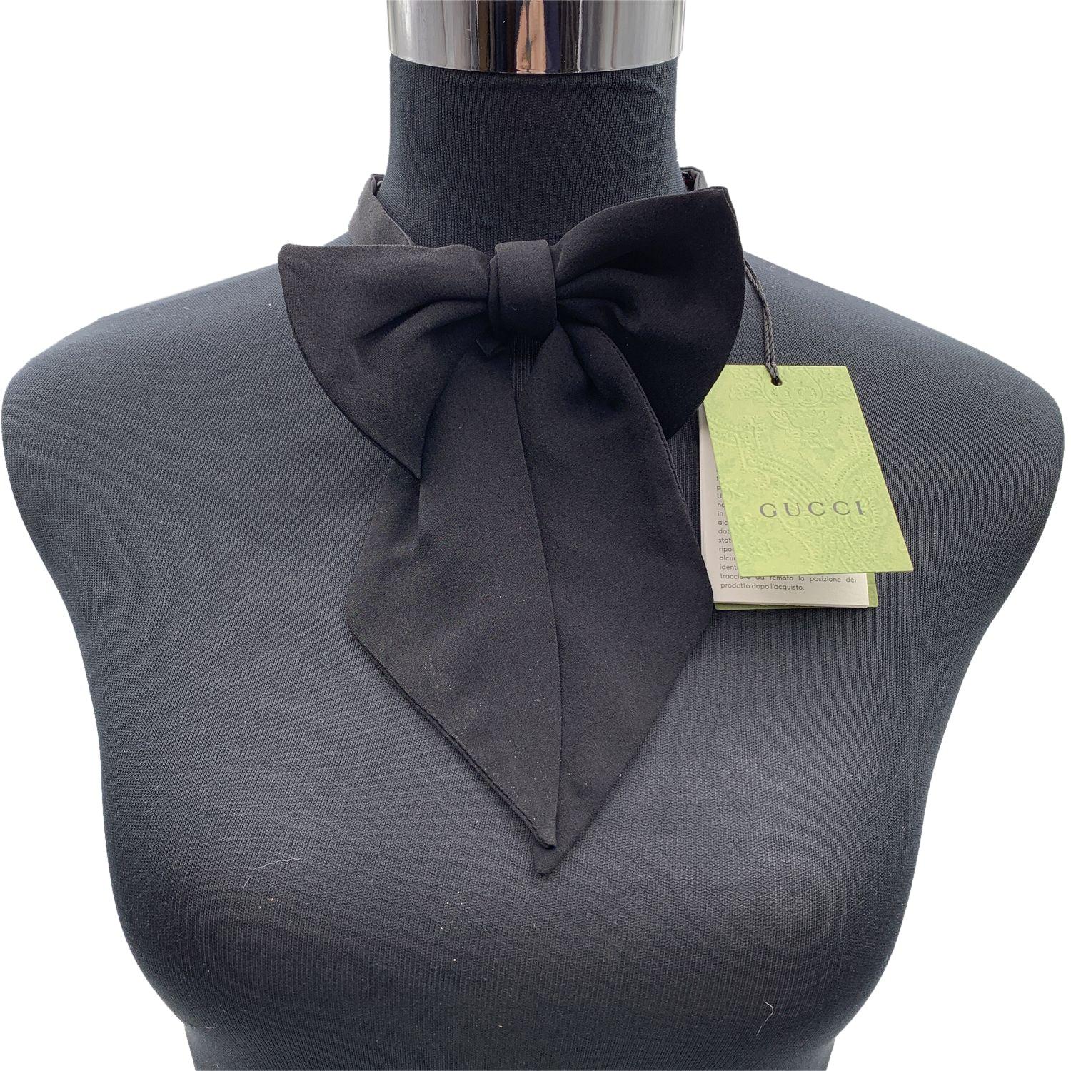 Elegant Gucci bow tie in black silk crepe. Pre-tied with elongated tips and adjustable back hook closure. Max width: 5.5 inches - 14 cm. Lenght of the strap around the neck: 15.5 inches - 39.4 cm Details MATERIAL: Silk COLOR: Black MODEL: - GENDER: