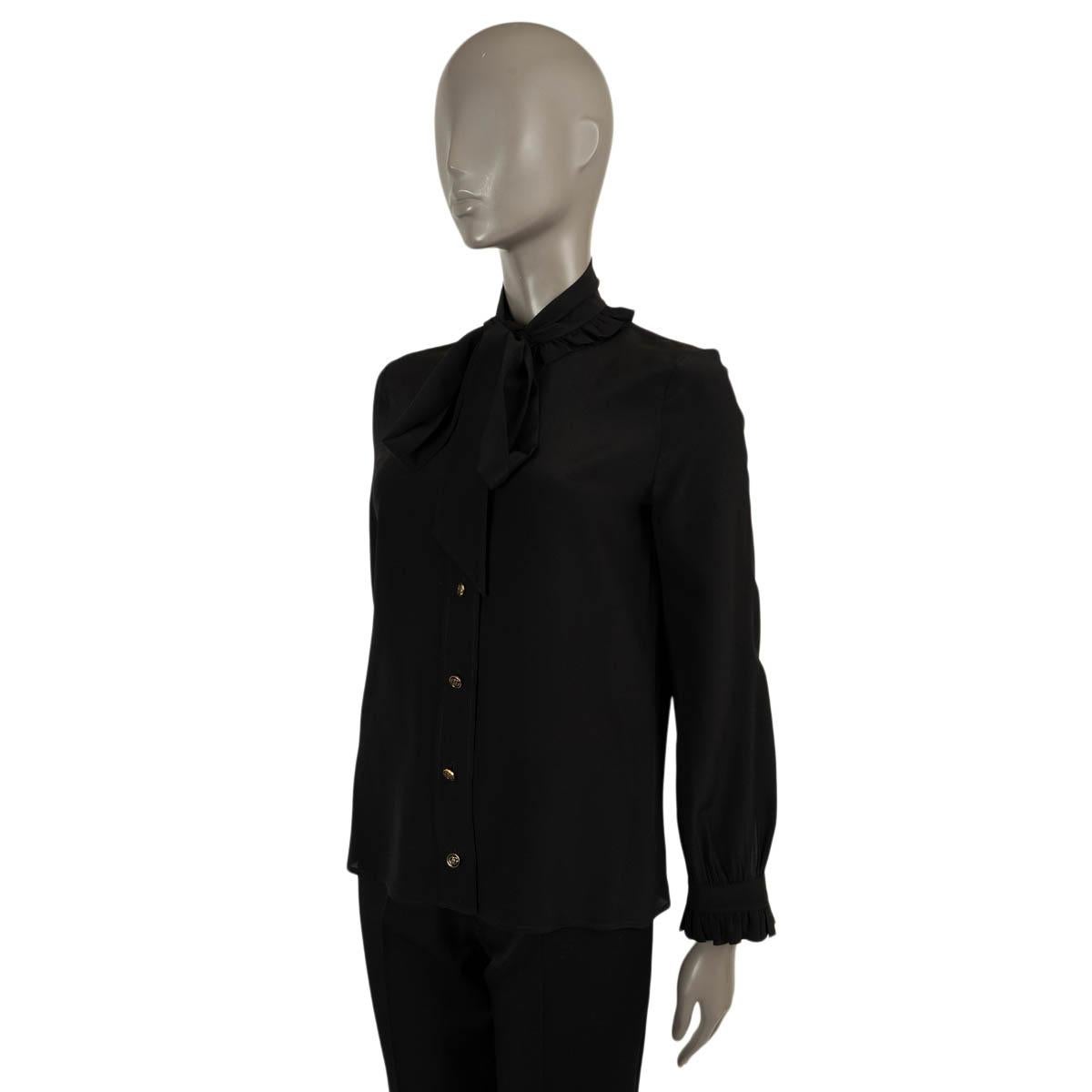 100% authentic Gucci pussy-bow blouse in black silk crepe (100%). Features ruffle trim along the neck and cuffs with buttoned strap detail. Closes with gold-tone logo buttons on the front. Has been worn and is in excellent