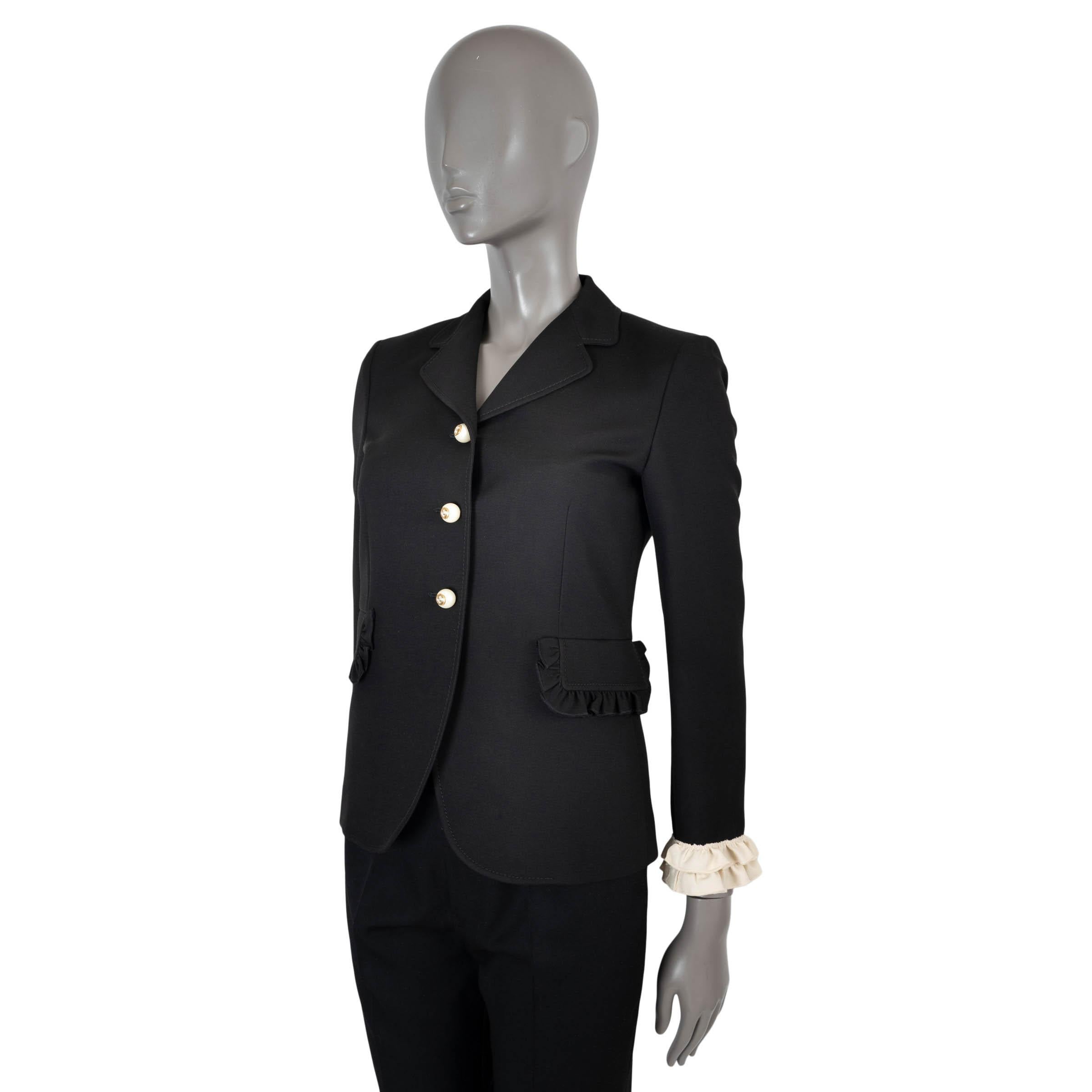 100% autentico blazer Gucci in cady crepe nero di lana (51%) e seta (49%) con bordi arricciati. Due tasche con patta, bottoni in finta perla con GG in tonalità oro antico. Foderato in acetato rosa (71%) e seta (29%). È stato indossato ed è in ottime