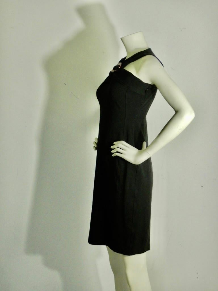 Black Gucci fitted dress.
Straps meet at the front in decorative Gucci logo piece.
Side zipper.
Rayon with elastane, some stretch for snug fit.
Tagged size large.

Shoulders: 12