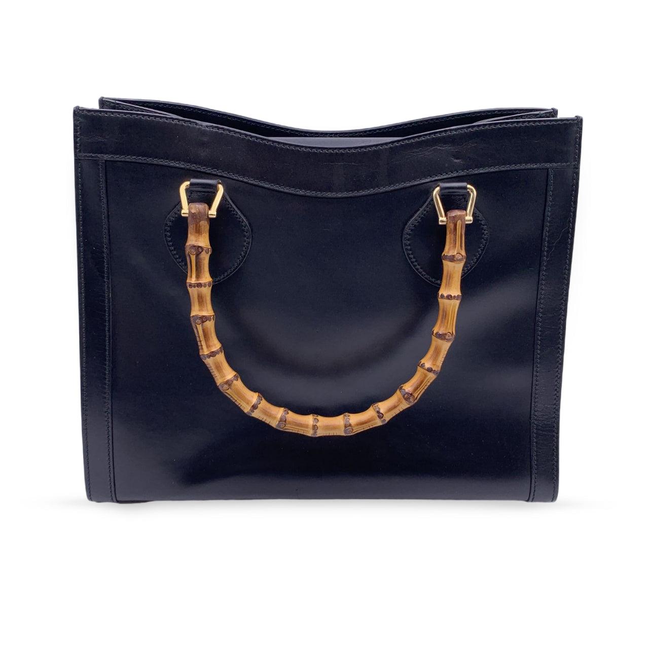 Beautiful Gucci Bamboo tote bag in black leather. Double distinctive Bamboo handle. Princess Diana, was snapped carrying a this model on several occasions. Magnetic button closure on top. 5 bottom feet. Gold metal hardware. 1 side zip pocket inside.