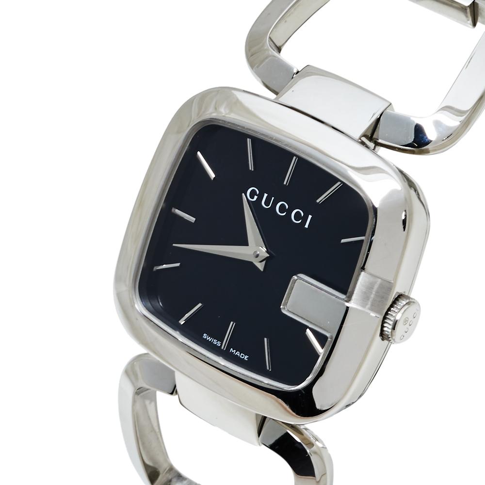 This G-Gucci wristwatch from Gucci is sleek and stylish. It comes with a signature G-shaped bezel, a gorgeous black dial with two hands and stick hour markers, and a bracelet finished with an engraved clasp. Make it a part of your everyday wear or