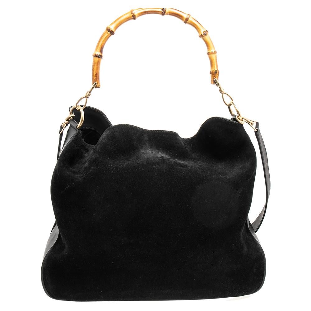 Diese Hobo aus dem Hause Gucci ist eine herausragende Kombination aus Brillanz und Stil. Machen Sie einen erstaunlichen Auftritt, indem Sie diese edle Tasche aus Leder und Wildleder in schwarzer Farbe schmücken. Sie verfügt über einen Bambusgriff