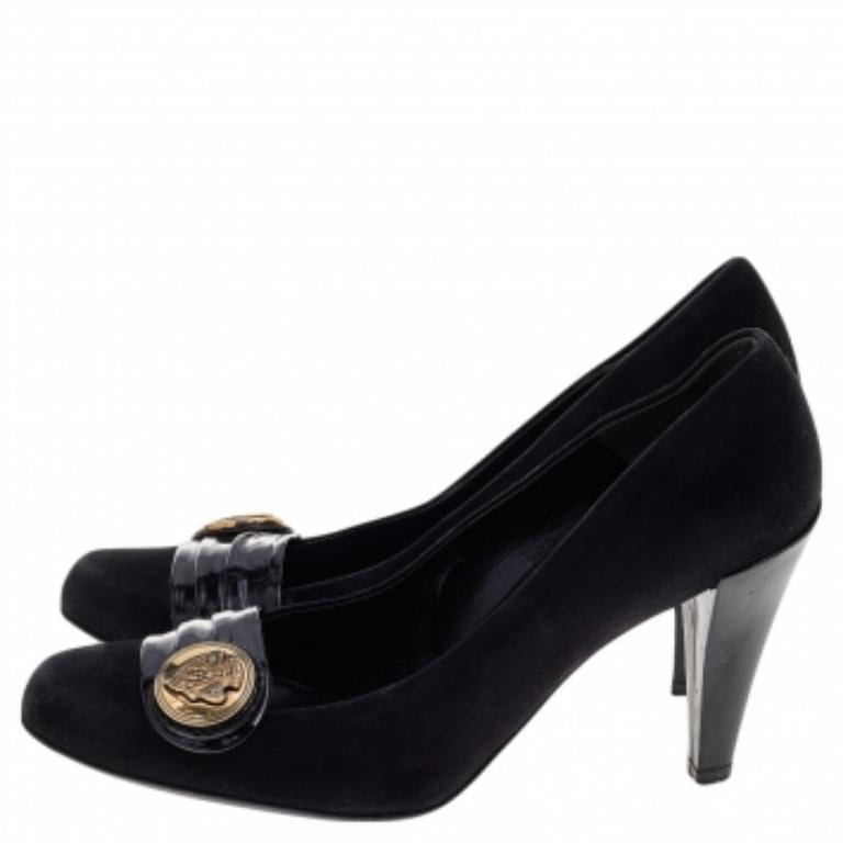 De la casa Gucci, estos zapatos de salón sólo aportarán estilo y garbo a tus pies. Están confeccionadas en ante negro y charol en el exterior, con un logotipo dorado en la puntera. Se completan con tacones de 9.5 cm.