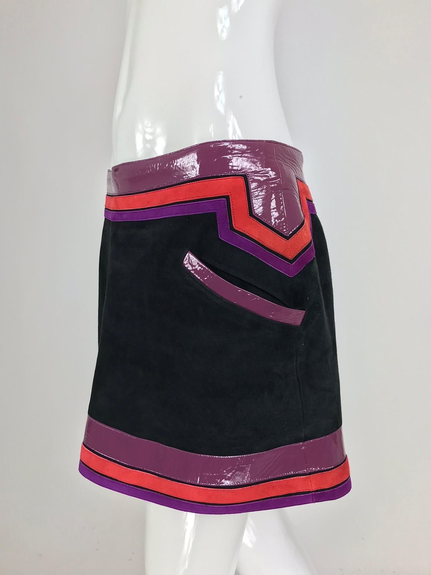 Gucci black suede skirt purple and red patent leather trim S/S 2007.  Hip hugging mini skirt of black suede with narrow bands of red and purple sued and wide bands and pocket trims of purple patent leather. Angled front pockets. The skirt is fully