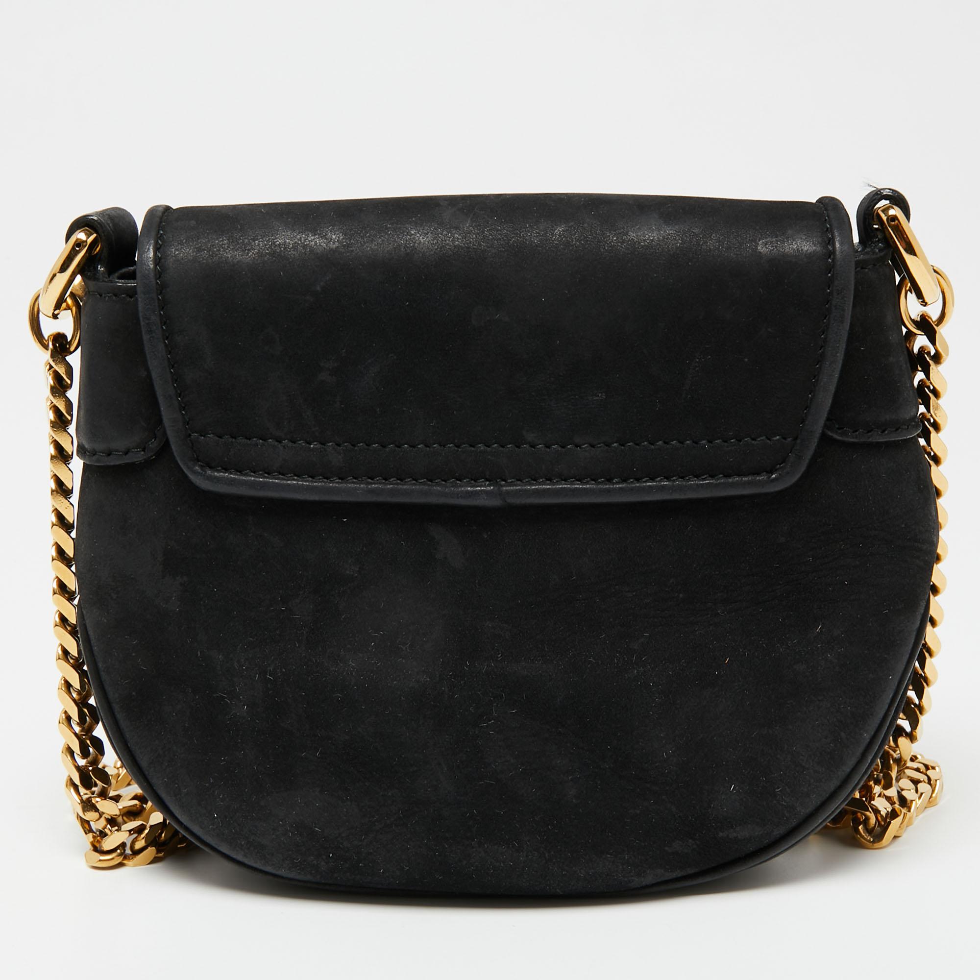 A coveted piece from Gucci is this black Tigrette shoulder bag. This beauty here is crafted from suede and the flap holds tiger heads connected by a gold-tone chain. The bag is grand in appeal and high in function.