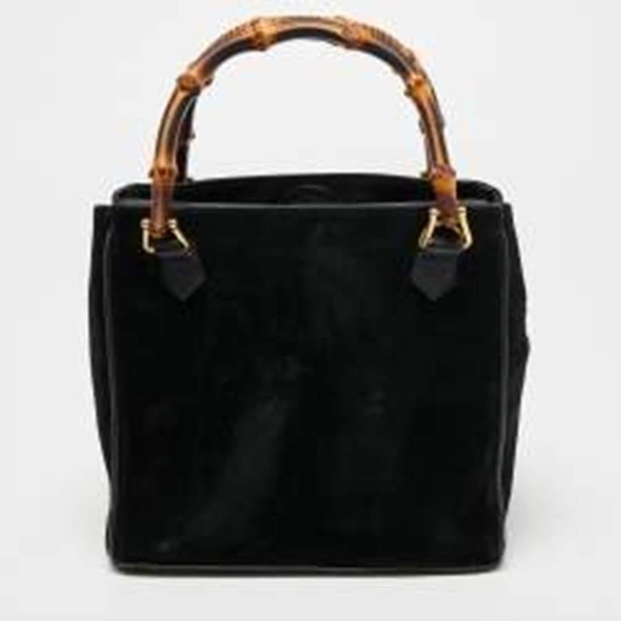 The luxurious and enduring details of this Gucci bag make it a wise investment. Created from suede, the design gets a classic update with dual bamboo handles at the top, and it is a versatile styling option The practical utility of this black