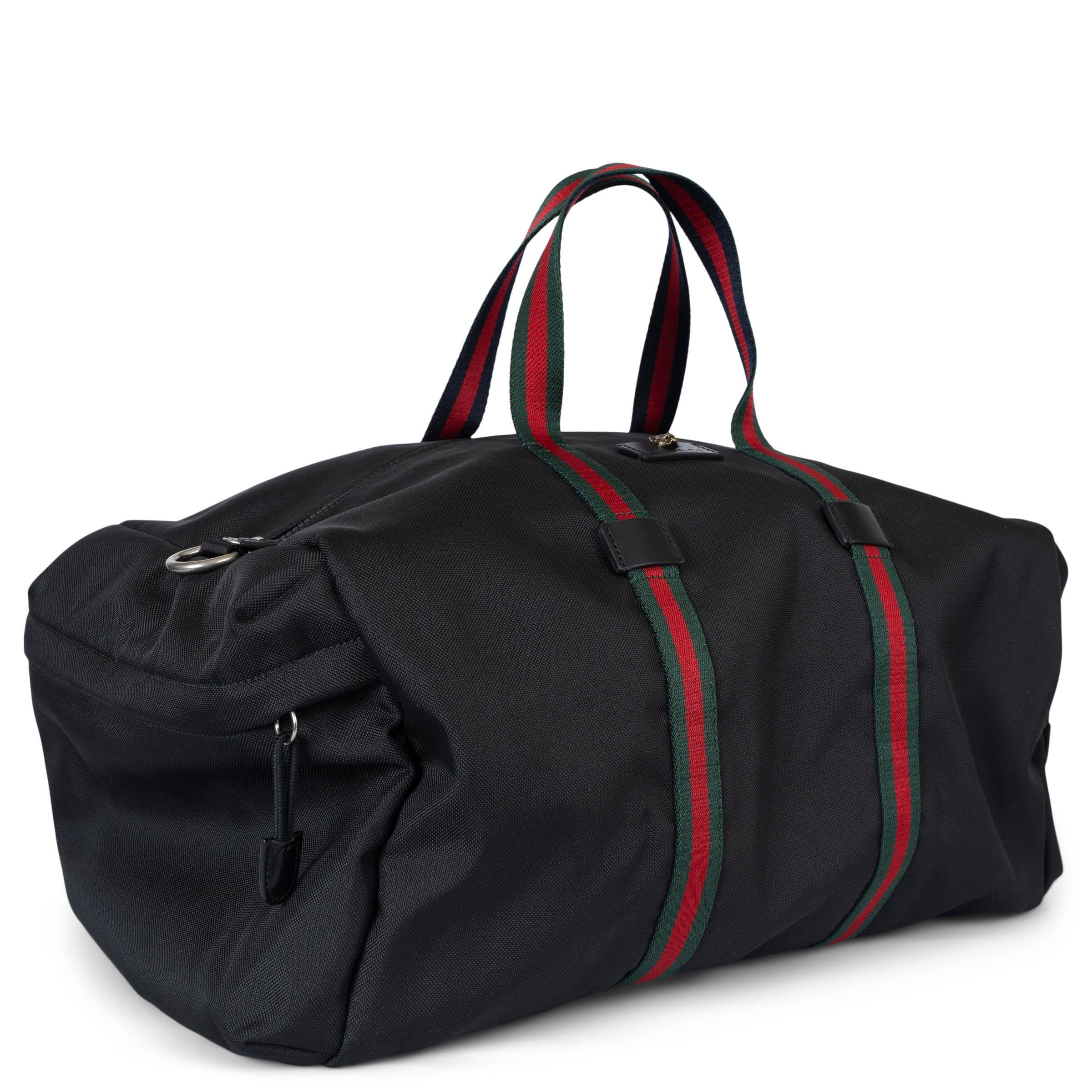 This 100% authentic Gucci Animalier carry-on duffle bag in black technical canvas combines practicality with signature Gucci style. It features iconic green-red web canvas straps that double as handles, an antique Feline-adorned logo leather patch,
