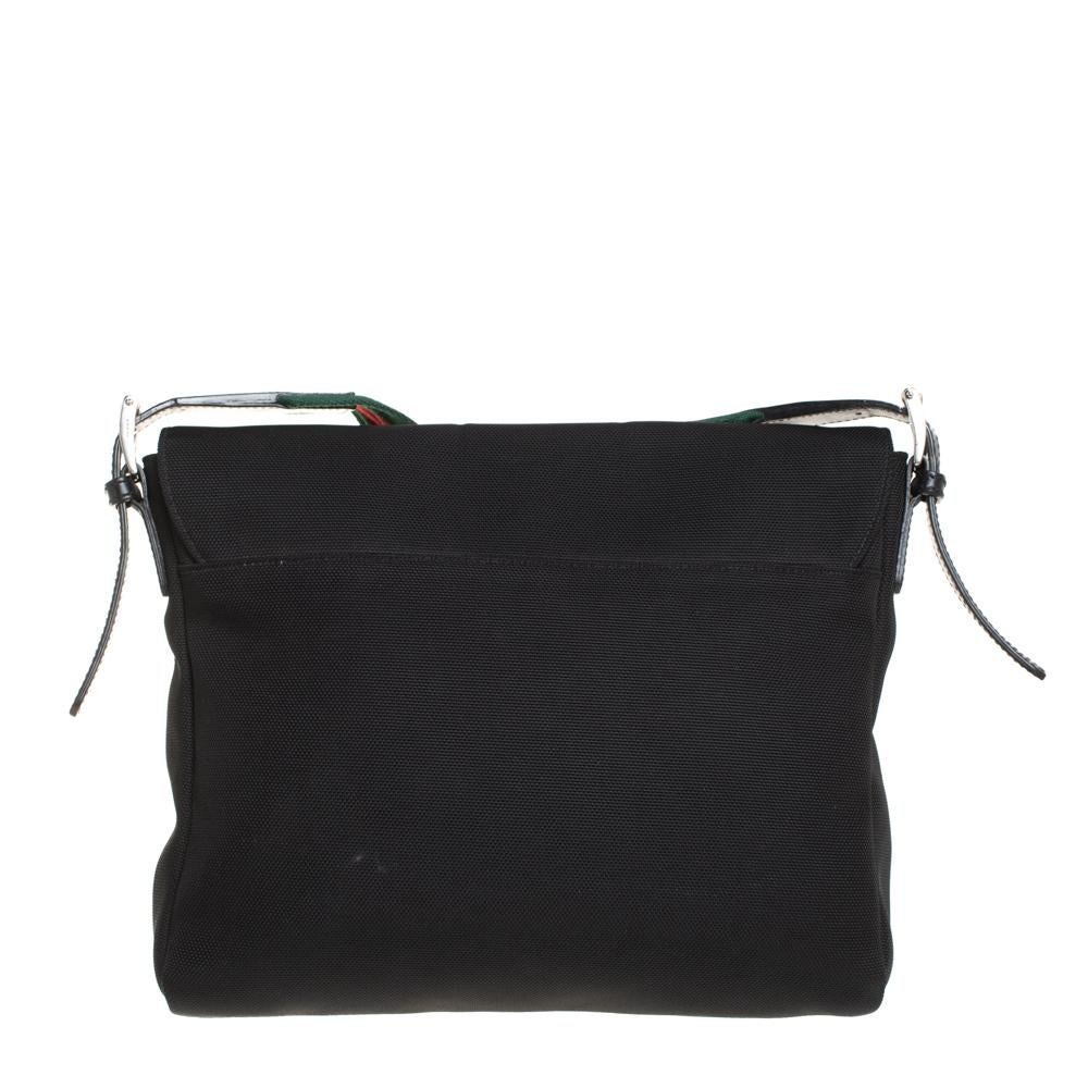 This messenger bag by Gucci is designed to be practical and stylish. Crafted from canvas, it features a flap closure and a .well-sized interior. The bag can be carried on the shoulder or as a crossbody using the Web shoulder