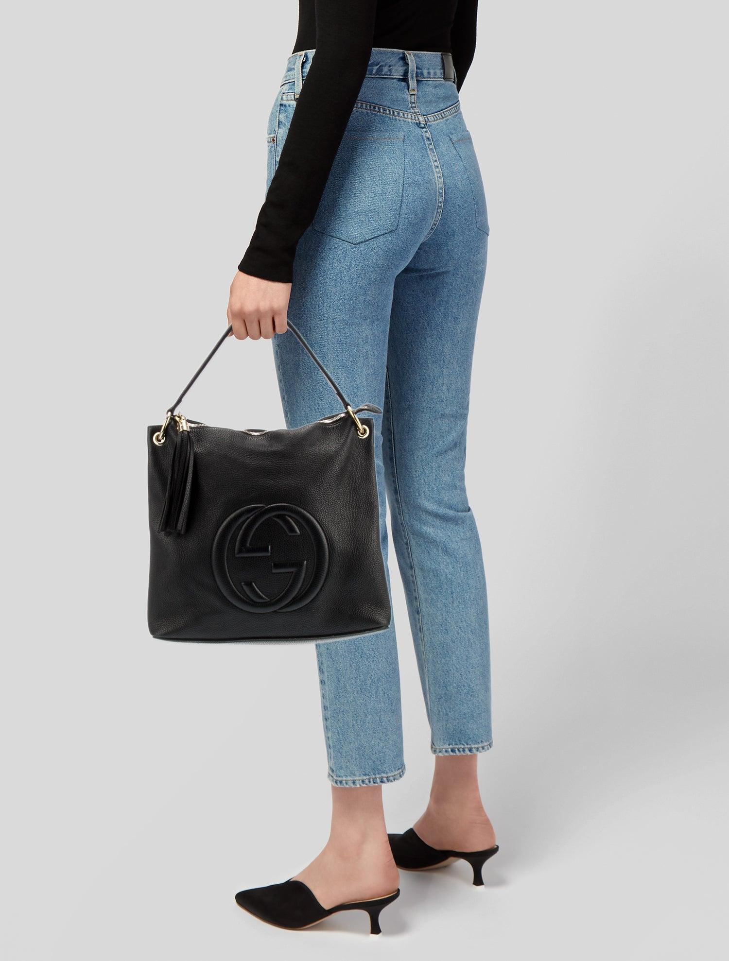 This Soho leather bag features a hobo design, pebbled leather in black, gold tone hardware, ﻿tassel accents, canvas lining and top zip closure. Designed by Alessandro Michele.

Color: Black
Material: textured/pebbled leather
Model No.