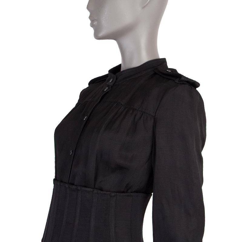 Tom Ford long-sleeve shirt dress in black viscose (72%) and linen (28%). With mandarin collar, epaulettes, one-button square cuffs, and belt loops. Closes with black buttons on the front. Lined in black silk (100%). Comes with corset belt that