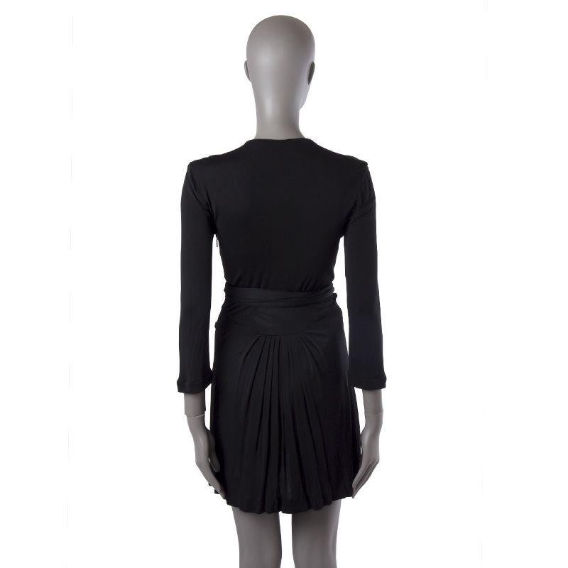 Gucci 3/4-sleeve jersey dress in black viscose (100%). With v neck, gathered front, GG bow decoration on the front in silver-tone metal, and pleated skirt. Ties on the front and closes with invisible side zipper. Hemline has been altered, otherwise