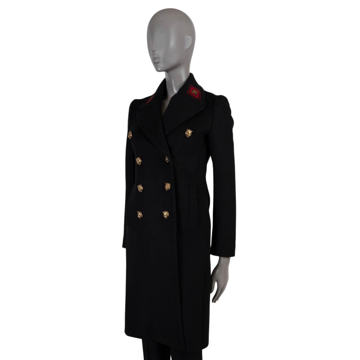 100% authentic Gucci peacoat in black wool (100%). Features large peak lapels with red bee embroidered patches, two slant pockets at the waist, a back belt with feline head buttons and L'Aveugle Par Amour and Snake embroidering on the back. Closes
