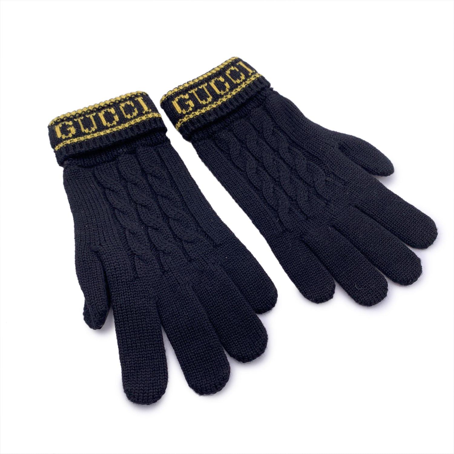 Beautiful and elegant knit gloves by Gucci. Black wool knit with yellow GUCCI signatures on the wrist. Leather side. Size M - 170/80 - 18,5 cm Details MATERIAL: Wool COLOR: Black MODEL: n.a. GENDER: Unisex Adults COUNTRY OF MANUFACTURE: Italy SIZE: