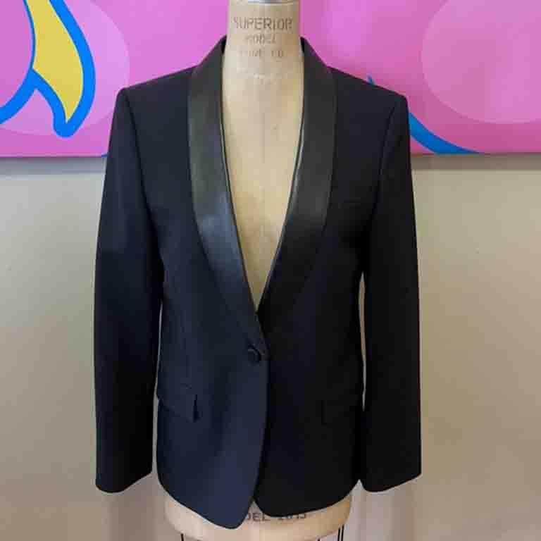 Special occasion dressing is easy wearing key pieces like this wool and leather trim tuxedo style jacket from Gucci. Pair with a black pencil skirt or pencil pants and a silk blouse for a finished look.

Size 42
Across chest - 18 1/2 in.
Across