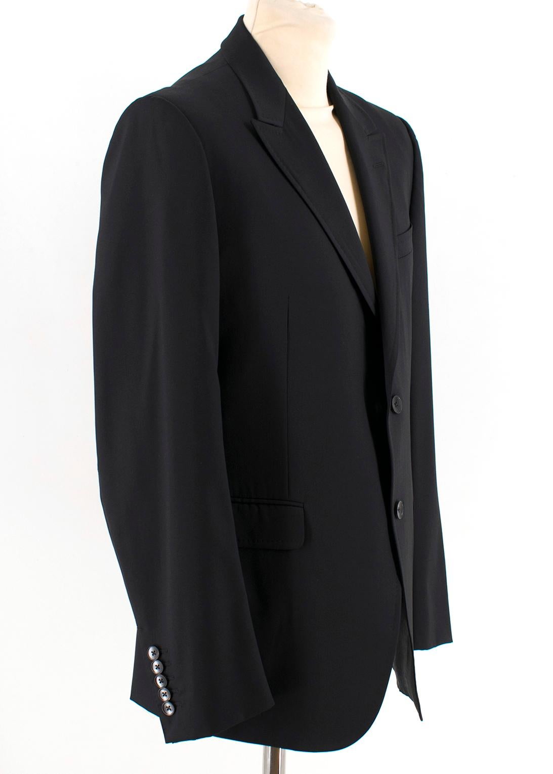 Gucci Black Wool Single Breasted Blazer

- Black single breasted blazer jacket
- Long sleeves
- Front flap pockets,
- Front chest welt pocket
- Padded shoulders
- Standard notch lapel collar
- Single back vent
- Button up cuffs

Please note, these