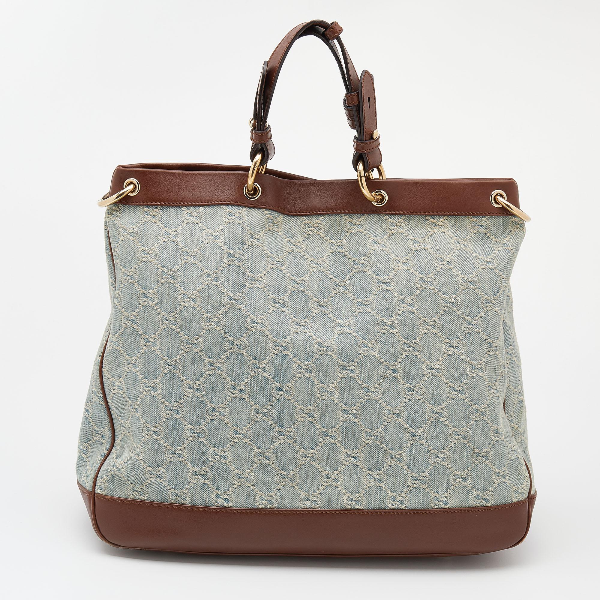 The house of Gucci brings you this Valentine tote made from denim with leather trims. The gorgeous blue and brown bag has dual handles, a shoulder strap, protective metal feet, and a spacious canvas interior. It is the perfect everyday