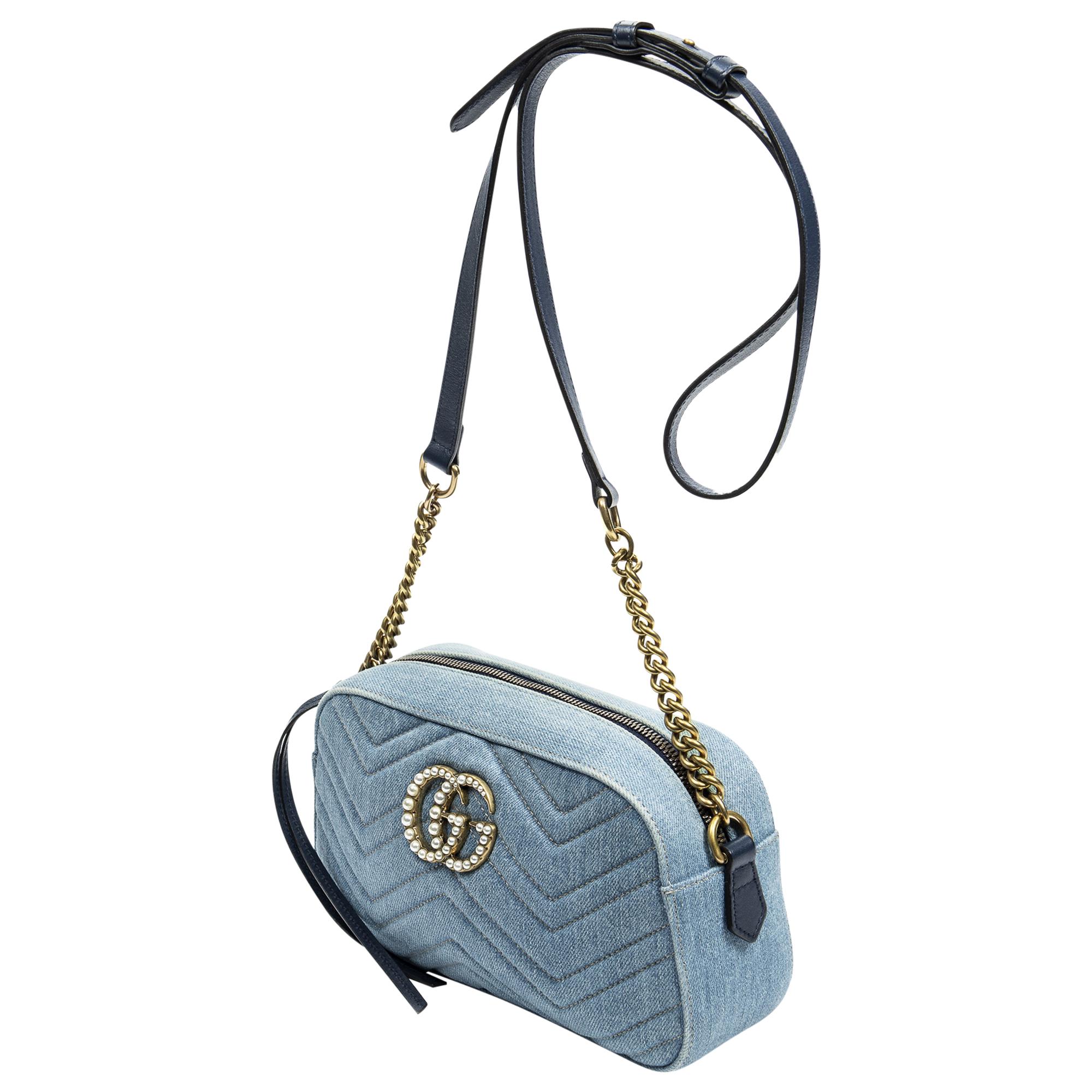 Elevate your casual chic with the Gucci Blue Denim Small GG Marmont Pearl Bag. Crafted from premium denim in a vibrant blue hue, it exudes effortless style. Accentuated with gleaming gold hardware and a convenient zipper closure, its satin-lined