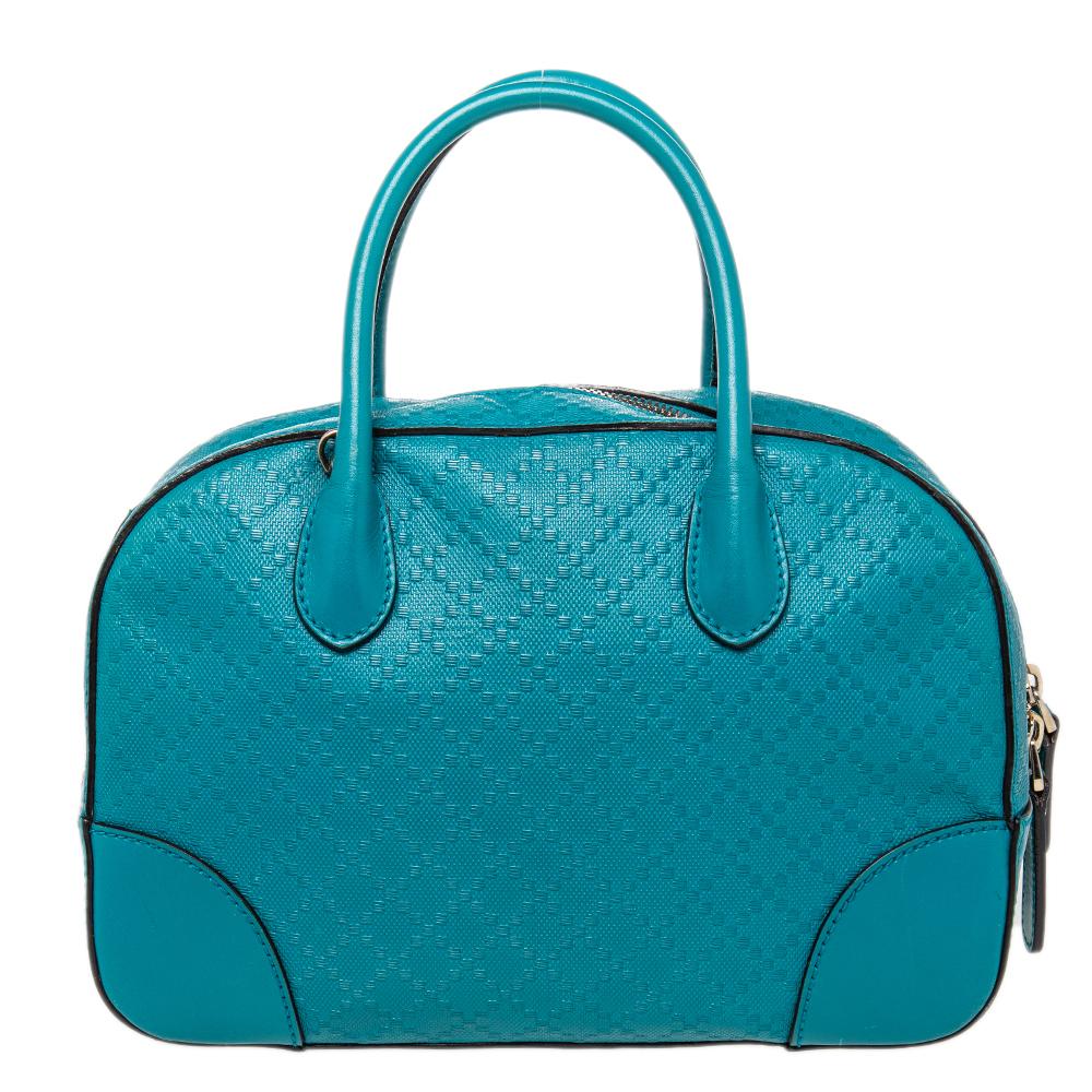 This Gucci satchel is a seamless blend of luxury and practicality. Crafted from blue leather with black piping, this bag features a wide zip closure and the Diamante pattern all over. It comes with two top round handles, a shoulder strap, and four