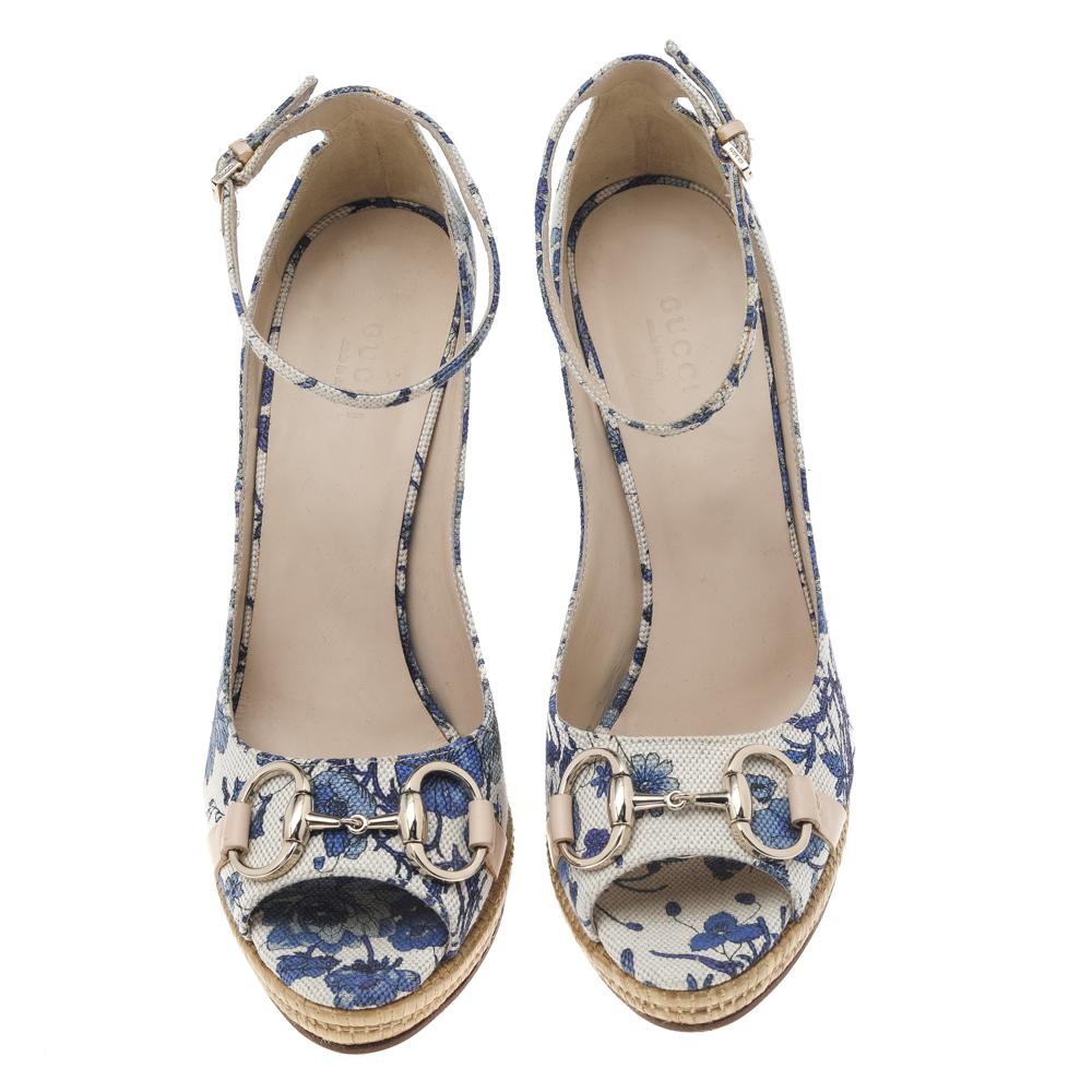 Enhanced with a floral print and a shapely silhouette, these sandals from Gucci will add a feminine edge to your feet. They are created using blue floral-printed canvas, with a gold-toned Horsebot accent placed on the peep-toes. They have wedge