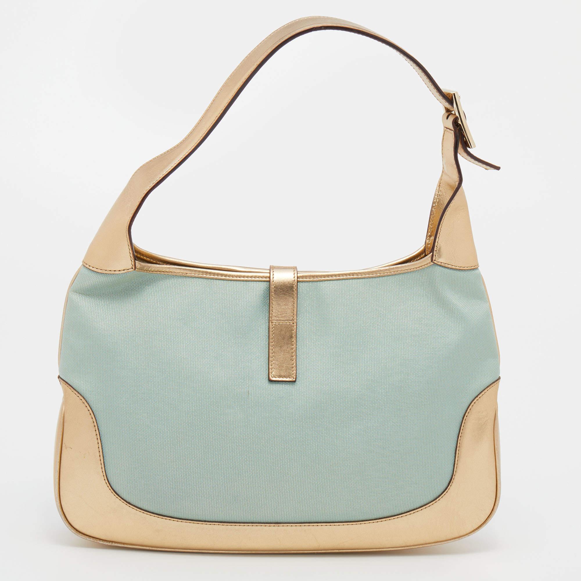 Gucci has always offered cult-favorite bags, just like this Jackie O hobo created as a homage to Jacqueline Kennedy Onassis. It is crafted from blue canvas and gold leather. A piston push-lock closure opens to a roomy interior that offers plenty of