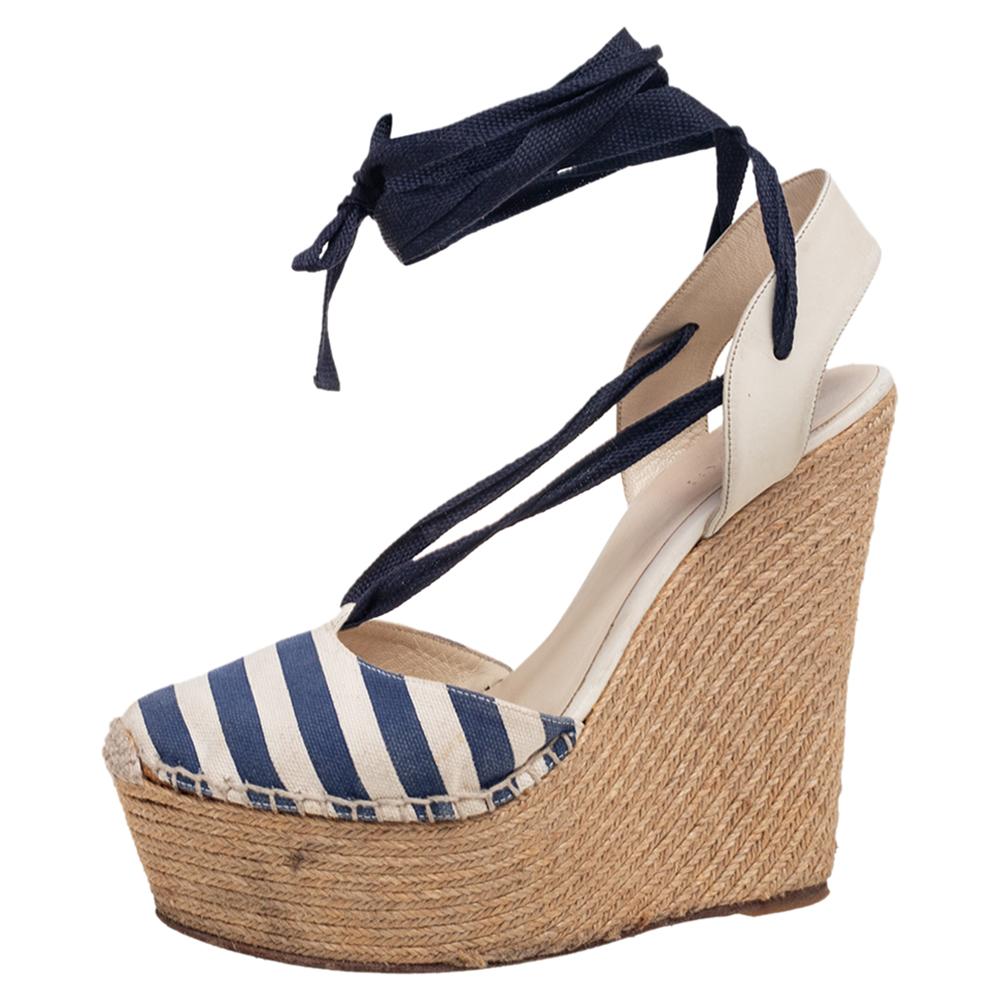 These chic sandals from Gucci are designed to elevate your spring-summer look instantly. They feature a blue and grey canvas and leather exterior with ankle-wrap ties to secure the feet properly. The sandals are complete with espadrille wedge heels