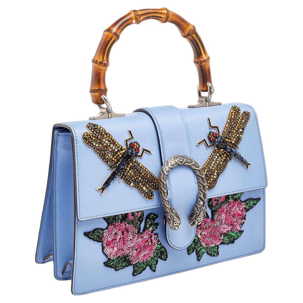 The much-loved Dionysus motif is complemented by sequin embellishments and a stunning bamboo handle making this top handle Gucci bag nothing short of luxurious. It is sewn using blue leather, secured by a flap, and lined with canvas.

Includes: