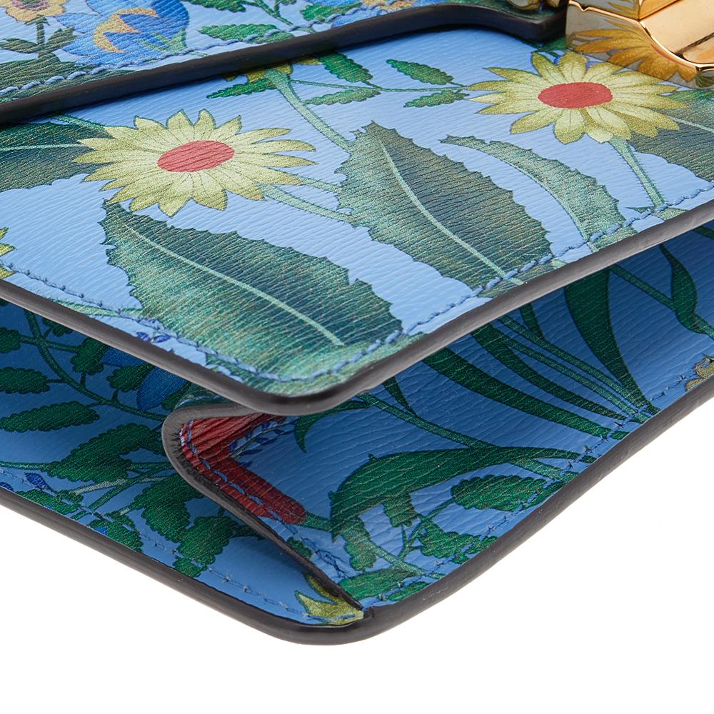 From the house of Gucci comes this gorgeous Sylvie shoulder bag that will perfectly complement all your outfits. It has been luxuriously crafted from floral printed blue leather and styled with a chain-web decorated flap and a buckle lock to secure