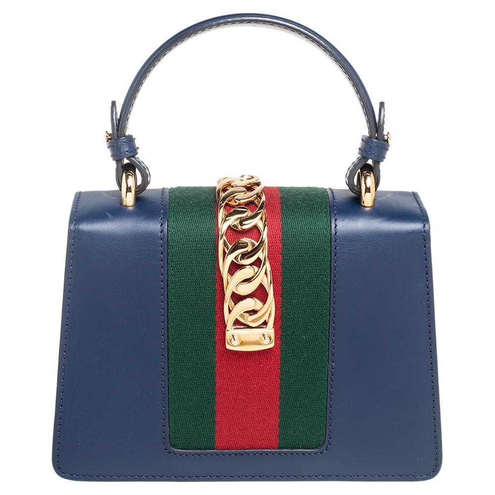 From the house of Gucci comes this gorgeous Sylvie shoulder bag that will perfectly complement all your outfits. It has been luxuriously crafted from blue leather and styled with a chain-web decorated flap and a buckle lock to secure the Alcantara